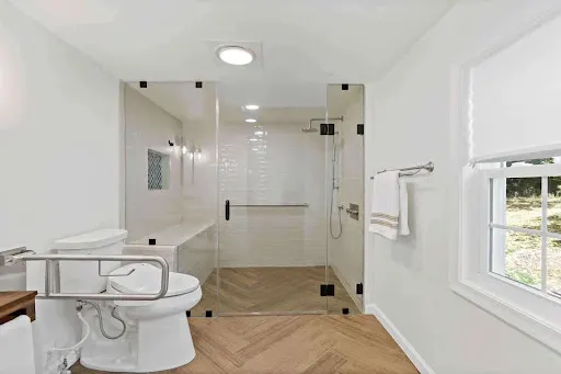 Barrier-free bathroom with a curbless walk-in shower and comfort supports