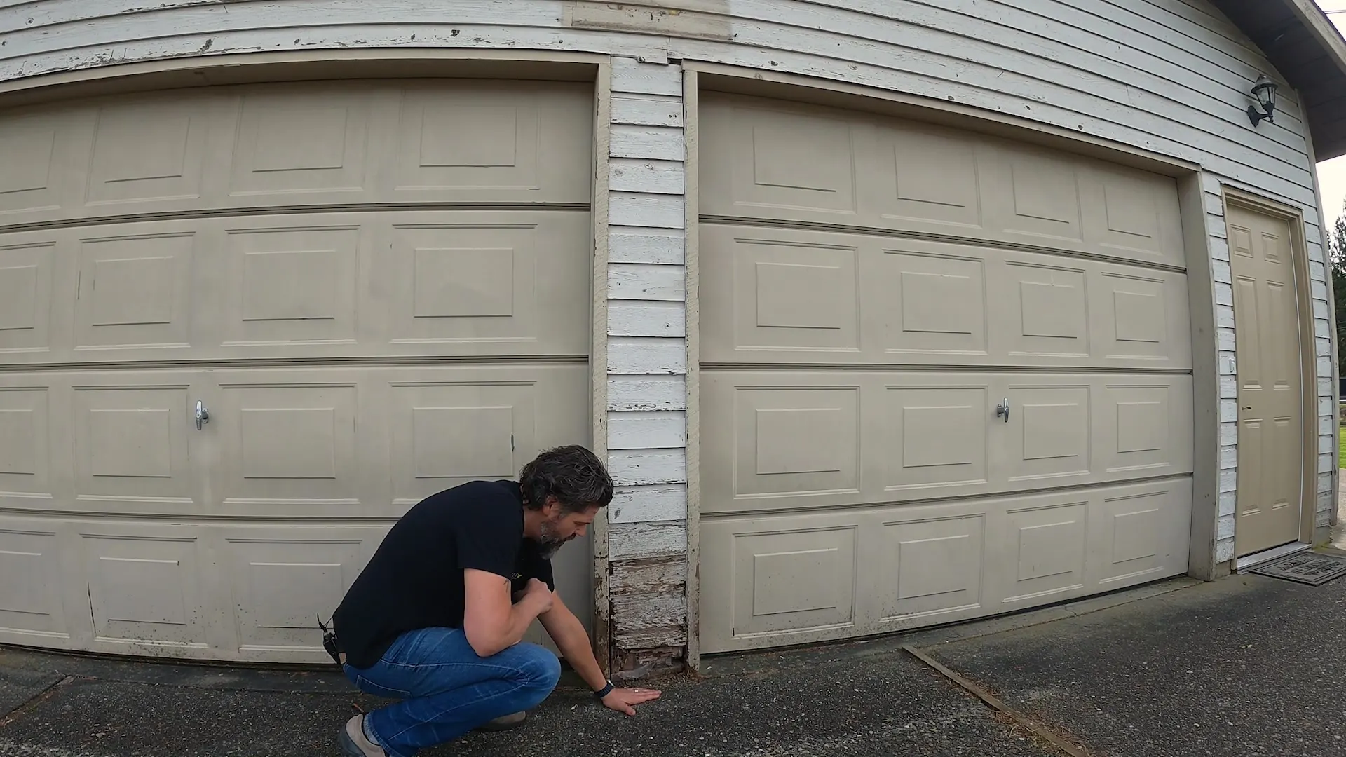 The original garage with heavy cream raised-panel wood doors