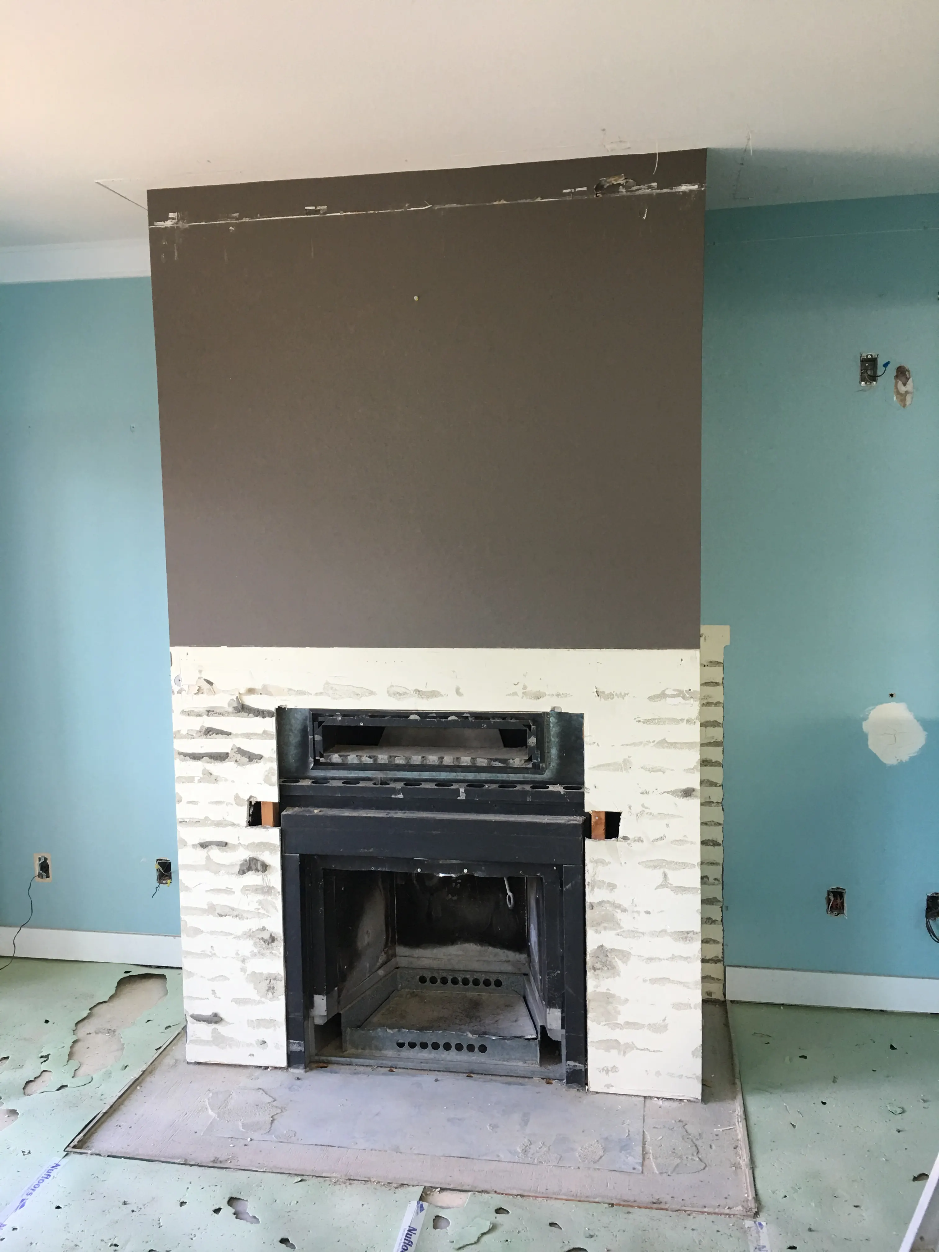 The original fireplace with a dated brick surround and a boxed-in chimney breast