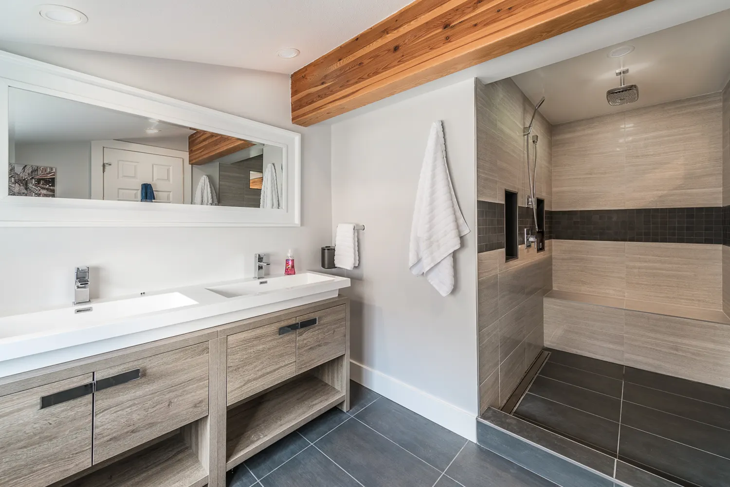 Spa-style ensuite with a double vanity, wood-beam accent, and a walk-in shower