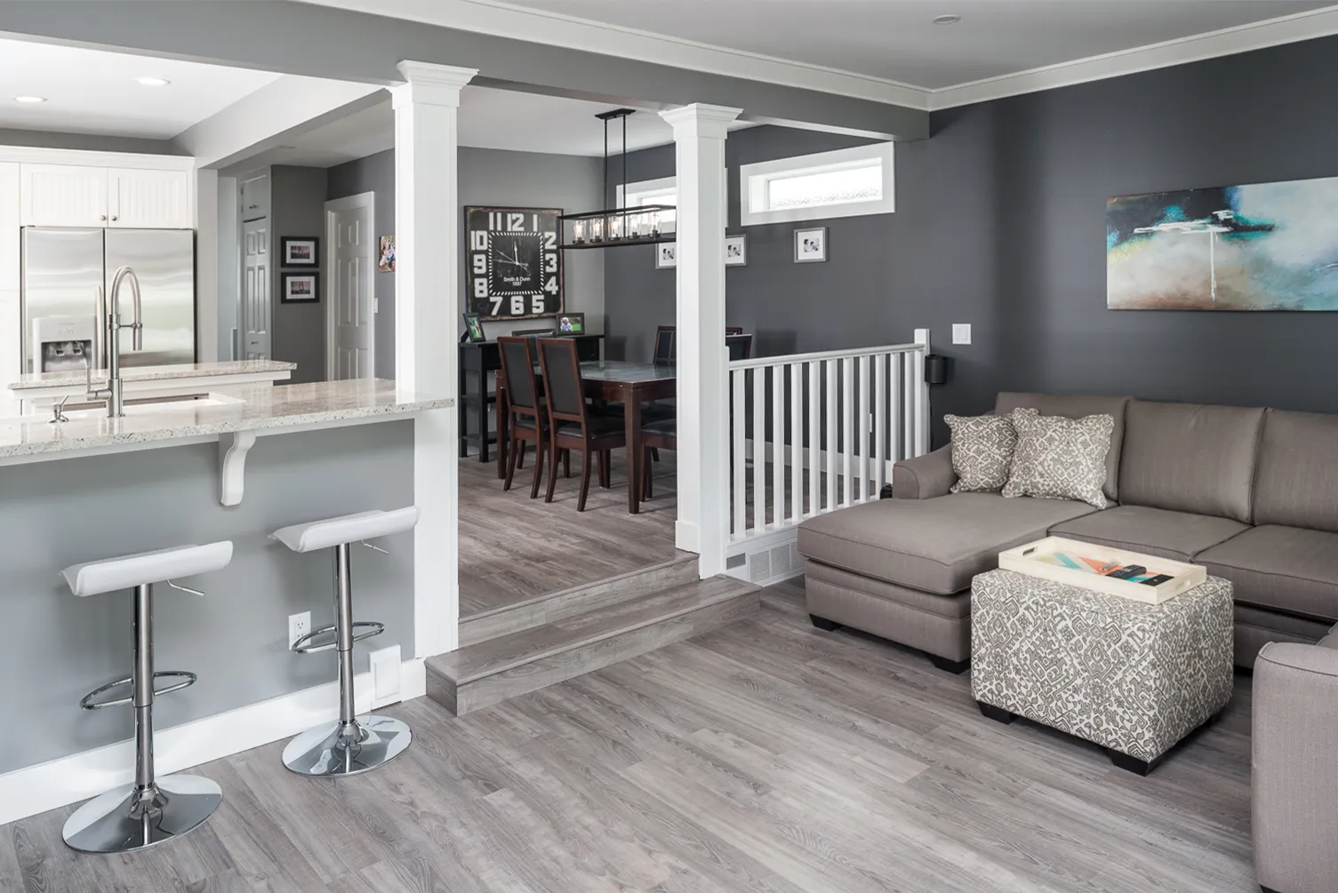 Open-concept kitchen with a large island, wood floors, and a staircase in the renovated Cultus Lake home