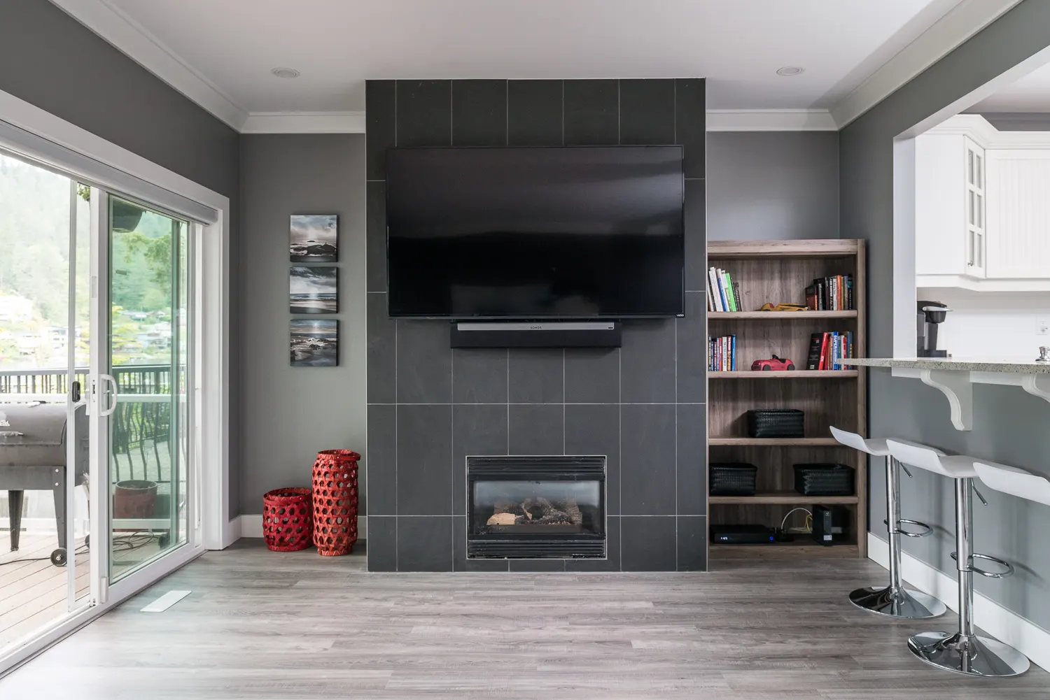 The new living room fireplace set into a full-height charcoal tile feature wall with built-in shelving