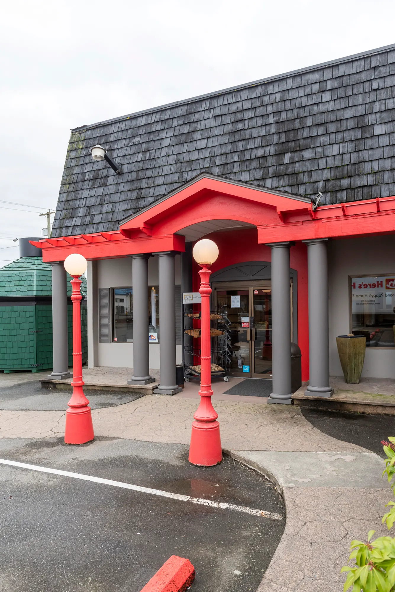 Red entry portico with columns and globe lamp posts at GP Home Furniture