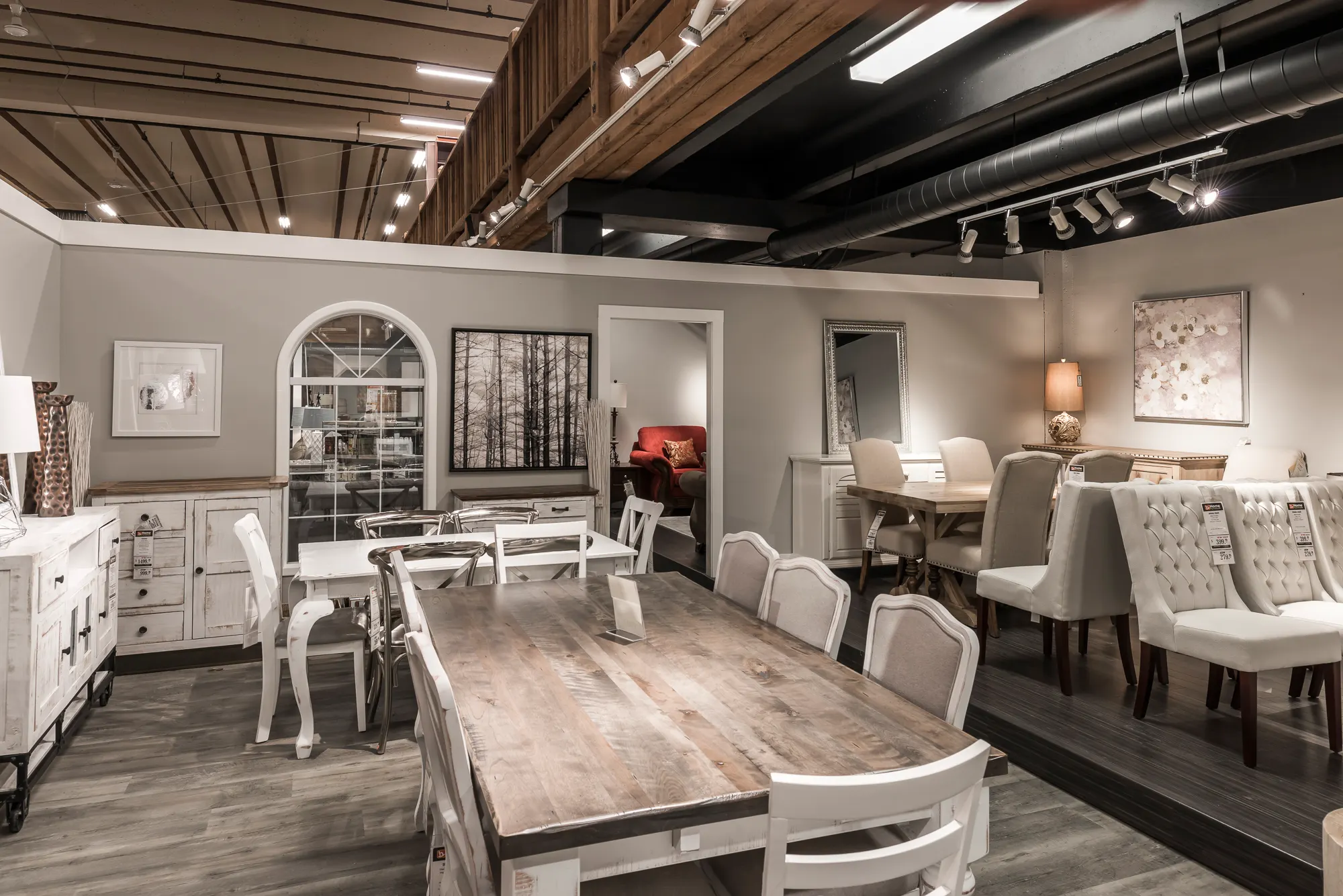 Farmhouse-style dining display with an arched window detail and white furniture