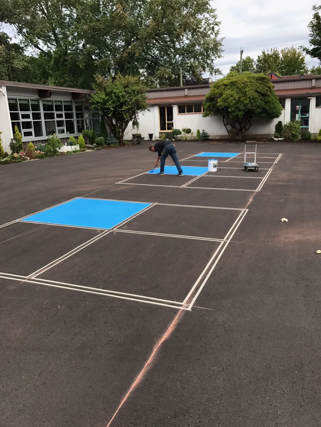 Master Painting & Renovations crew laying out fresh parking lot markings