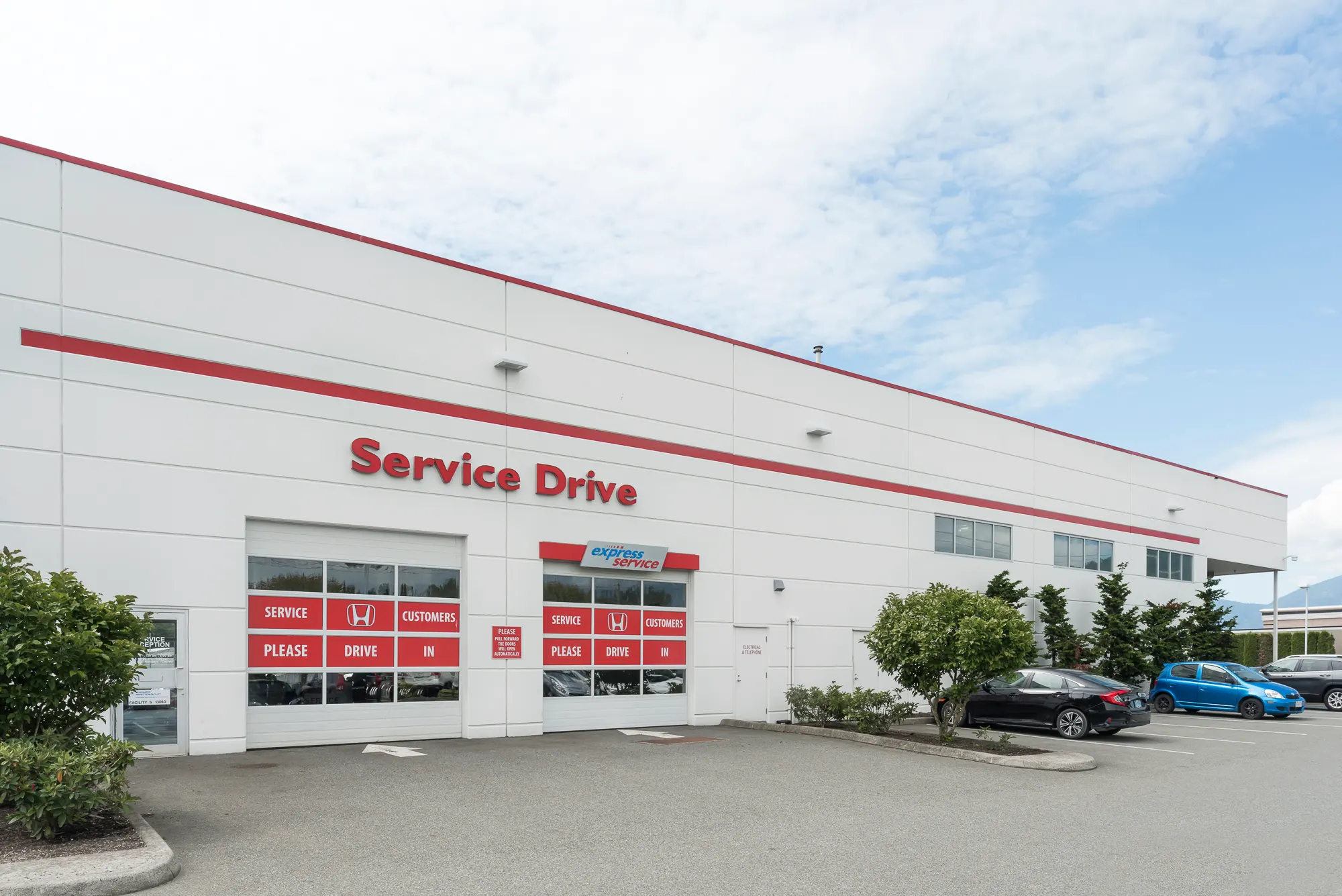 Service Drive entrance with red signage and drive-in bay doors