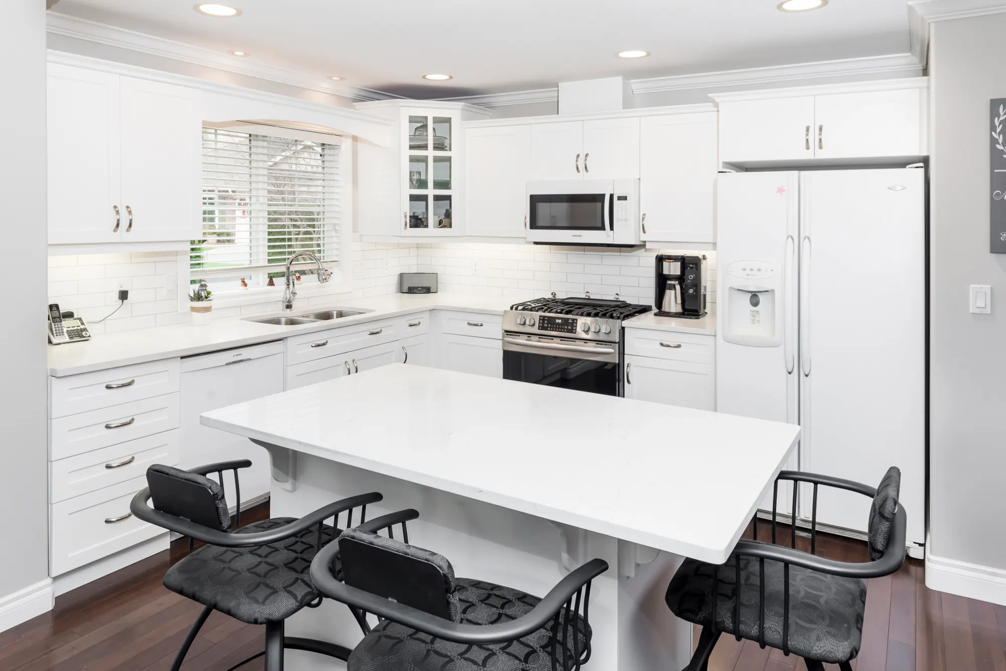 Bright white kitchen renovation with quartz island in Chilliwack by Master Painting & Renovations