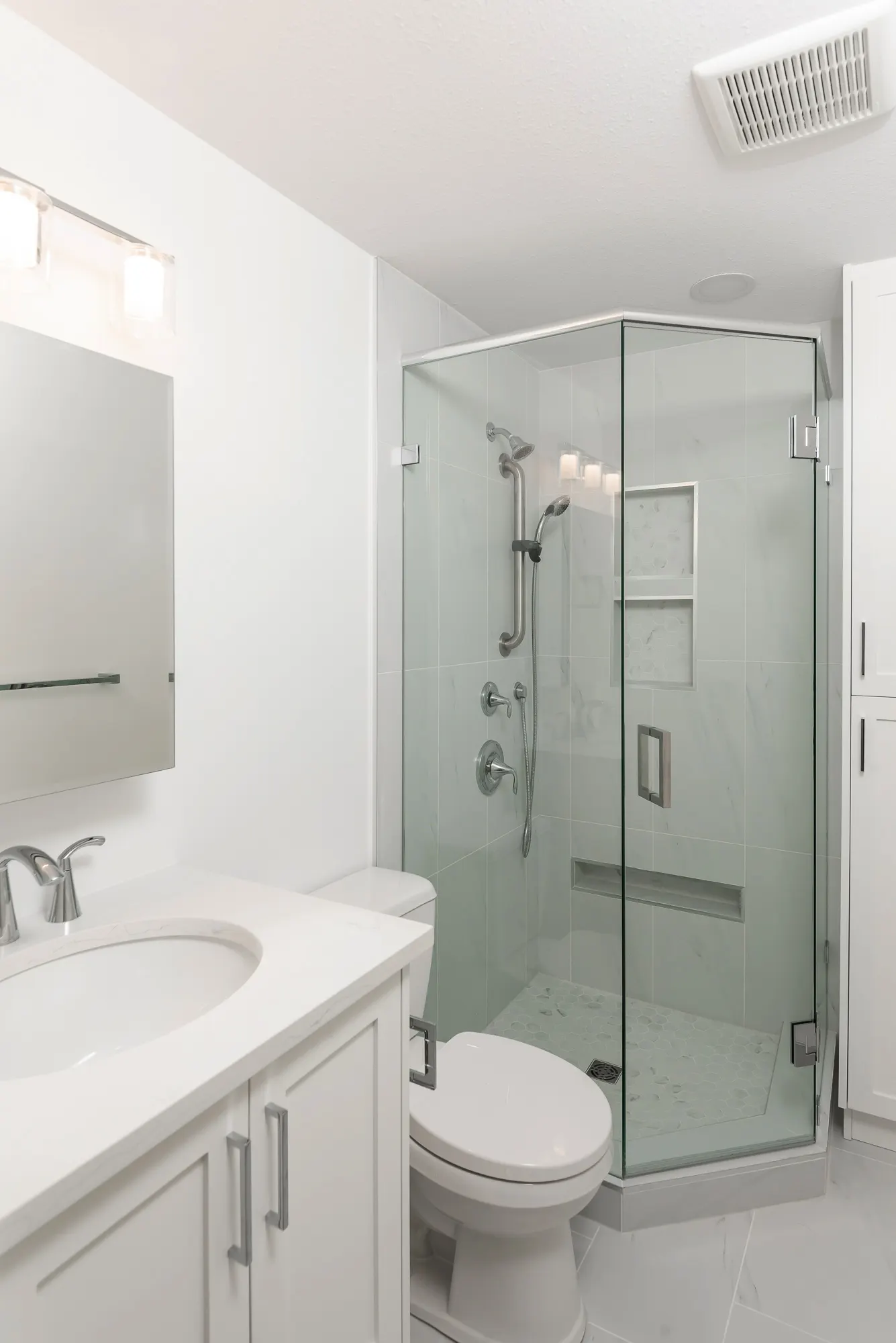 Renovated bathroom with a glass corner shower, tiled niches, and a quartz vanity, Chilliwack BC