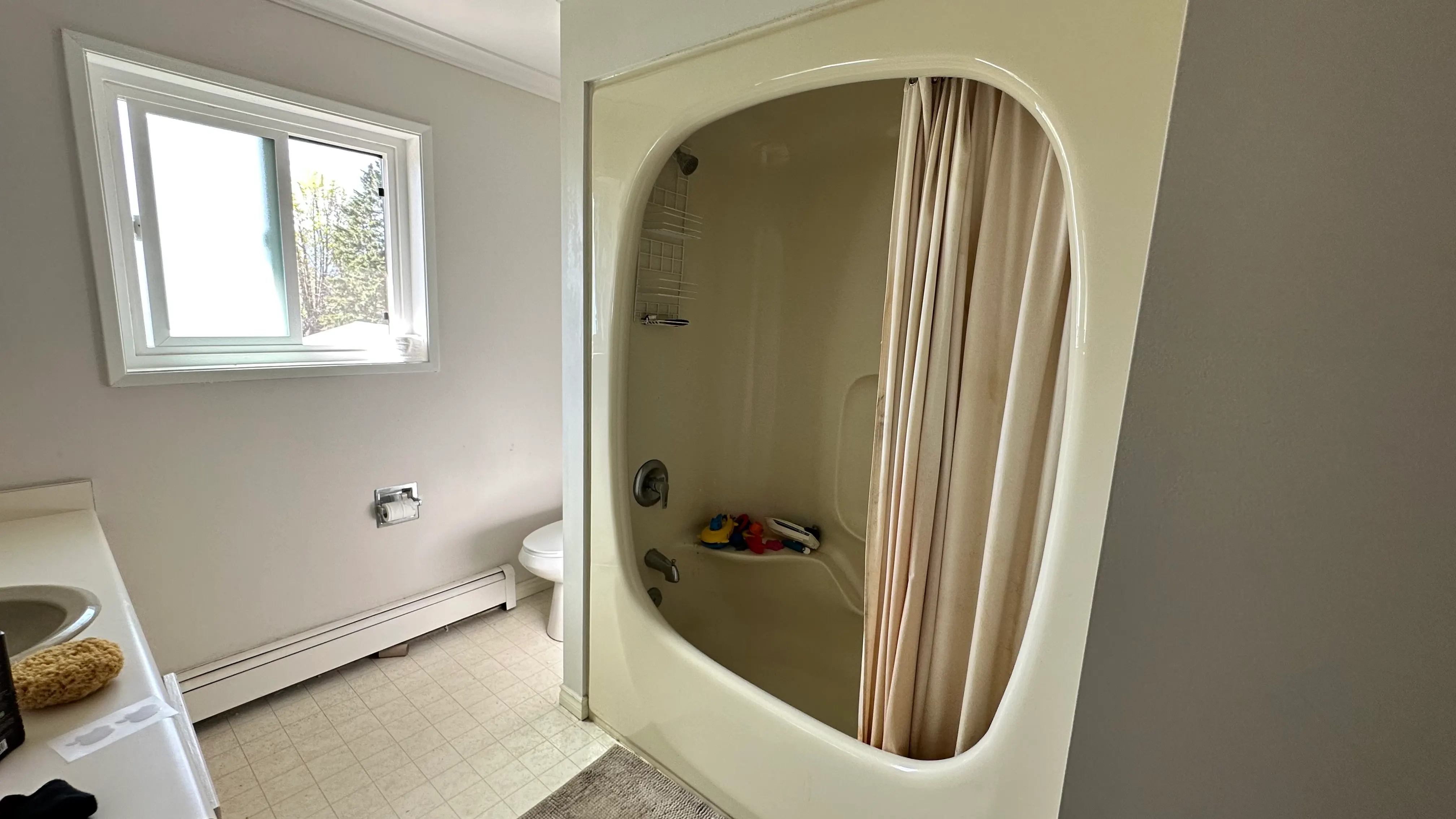 The original bathroom with a dated one-piece fibreglass shower surround