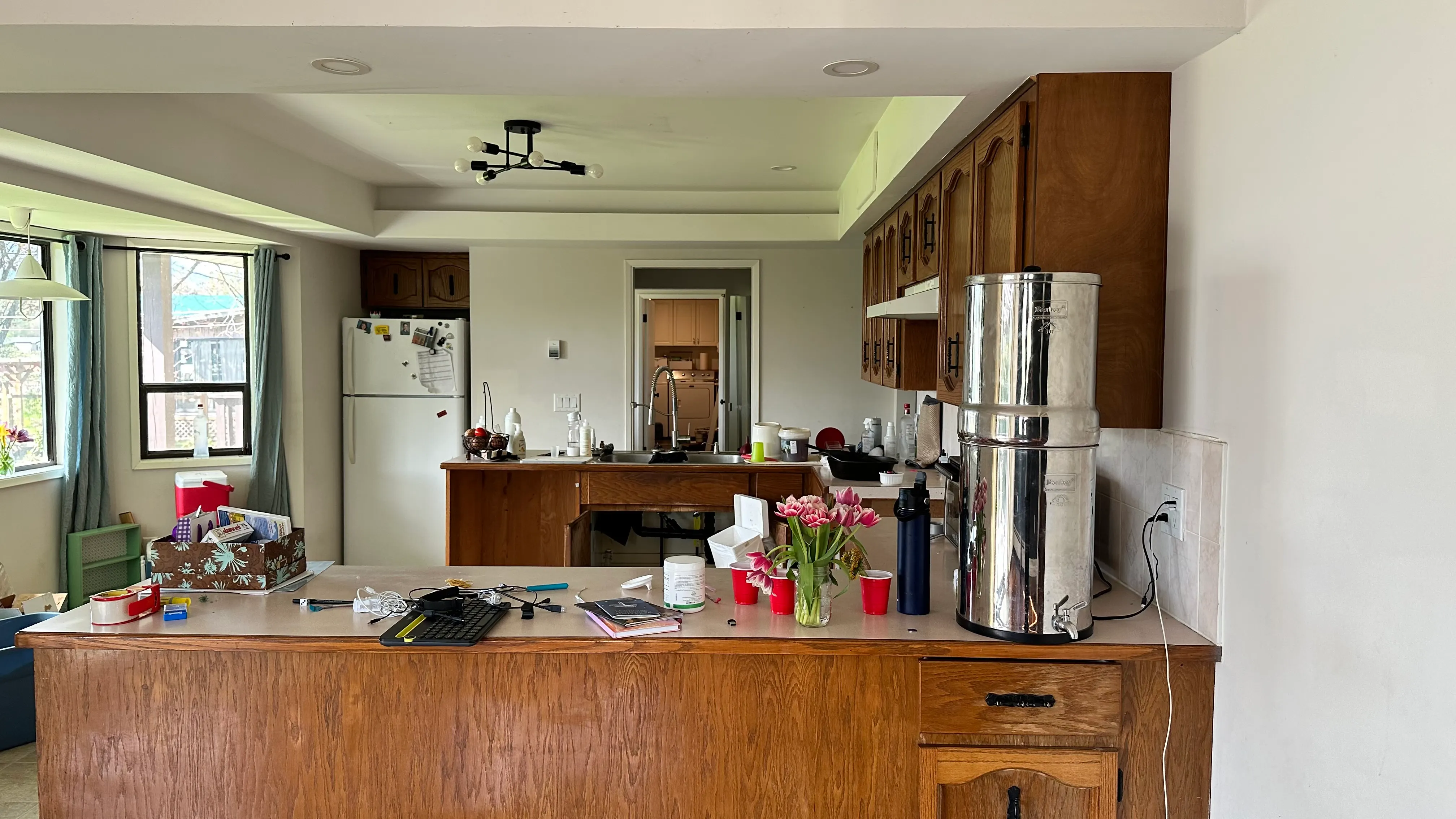 The original kitchen with oak cabinets, a laminate peninsula, and older appliances