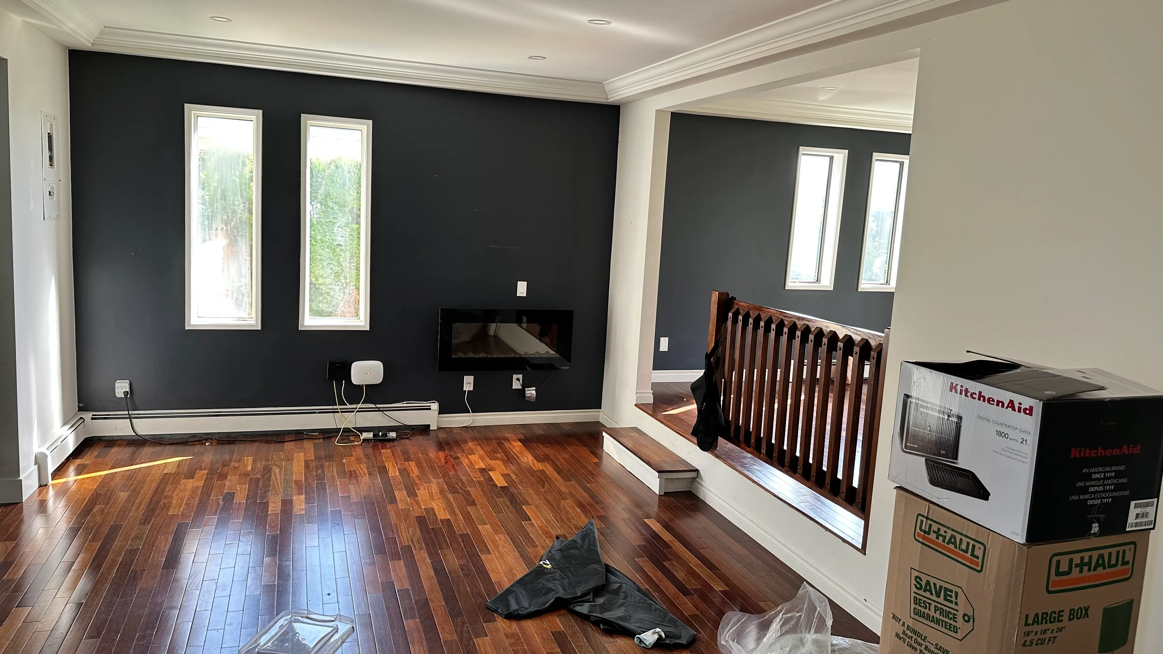 The original sunken living room with a dark accent wall and an oak spindle railing