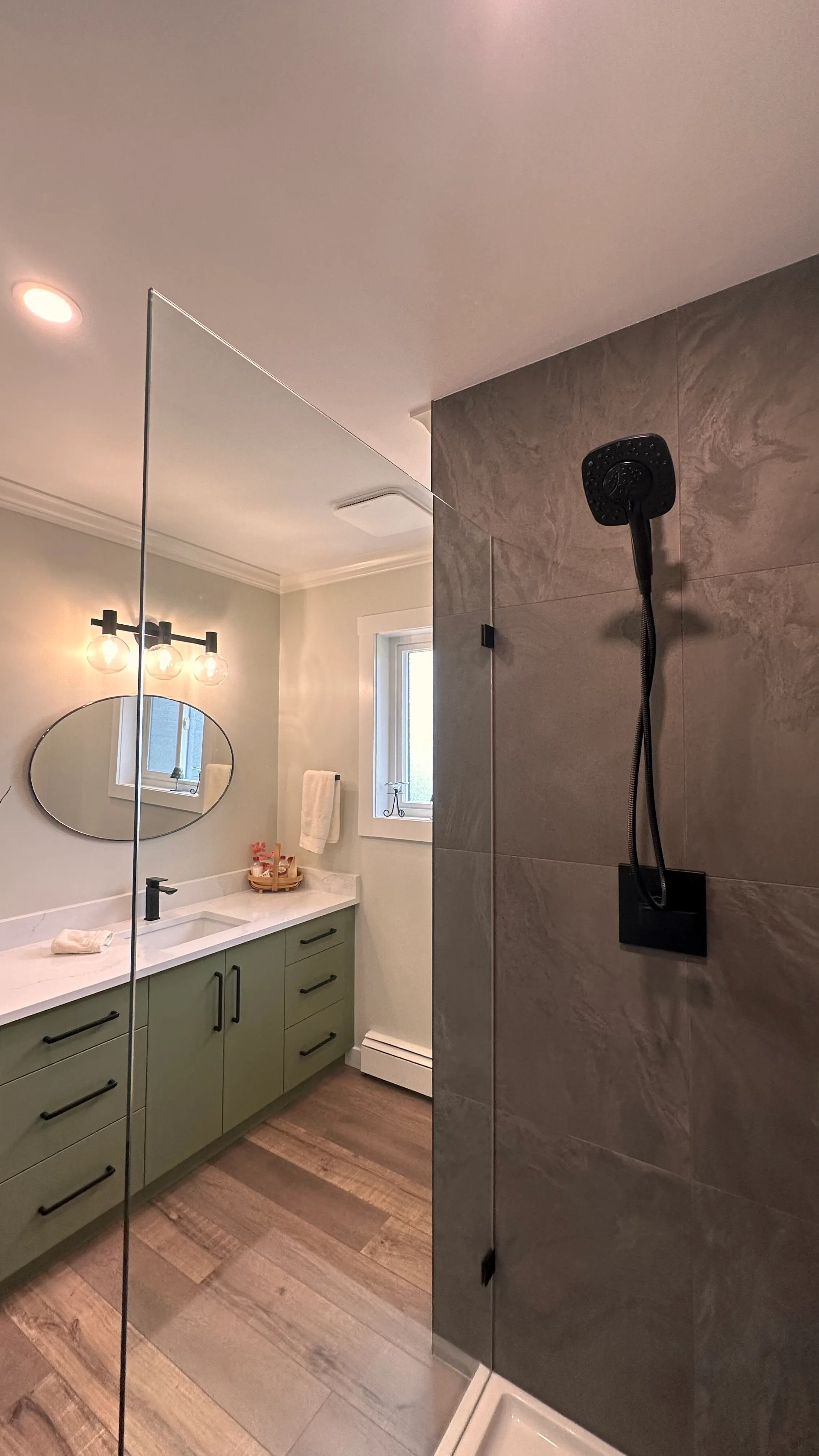 Tiled glass walk-in shower with black fixtures and a floating vanity