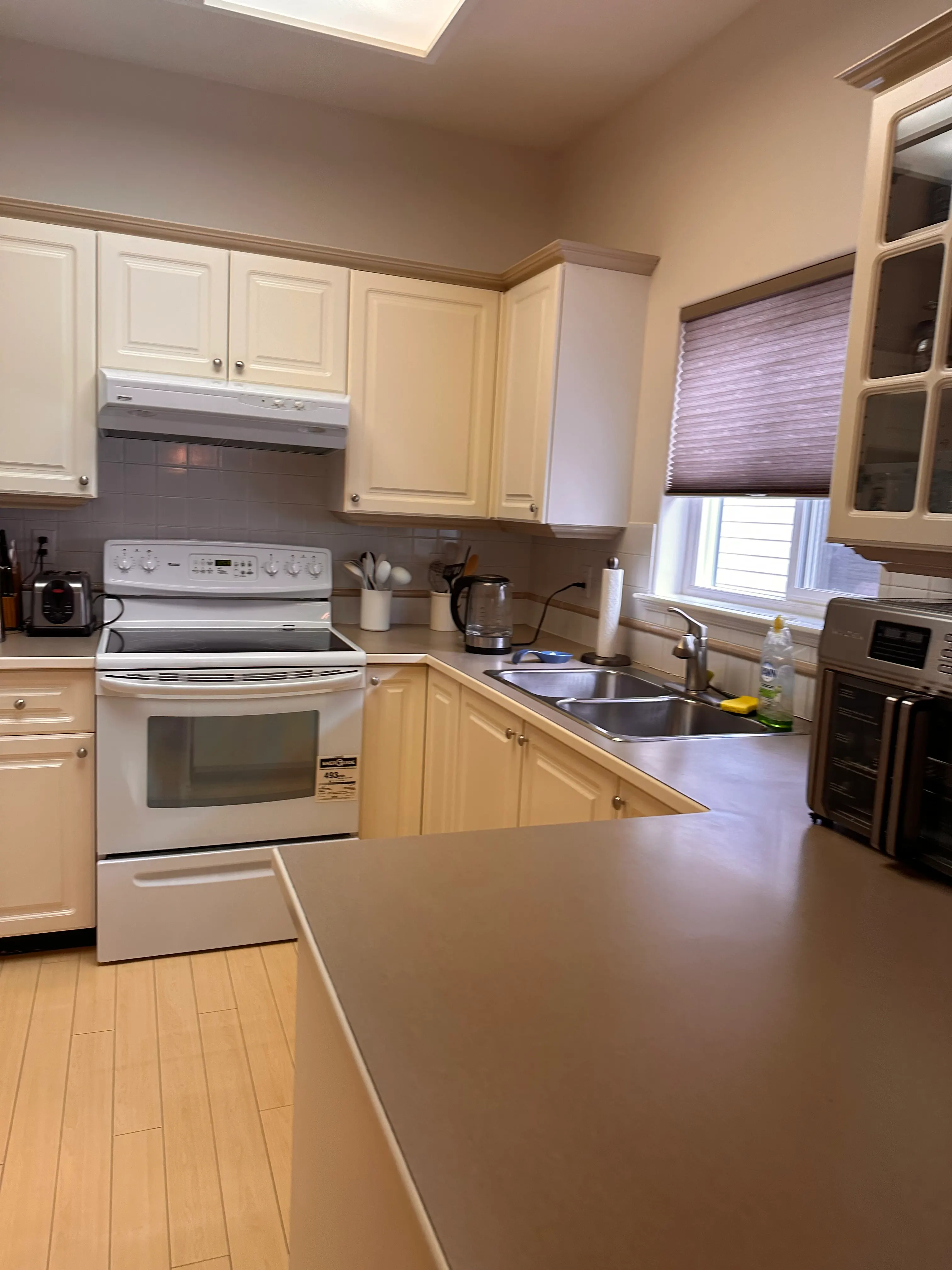 The original kitchen with cream cabinets and mauve laminate counters