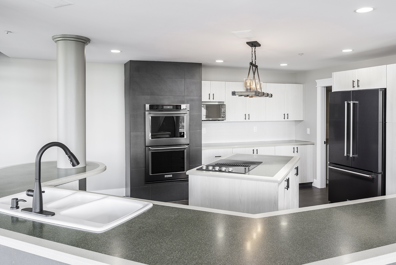 Modern kitchen with dark appliances and island cooktop