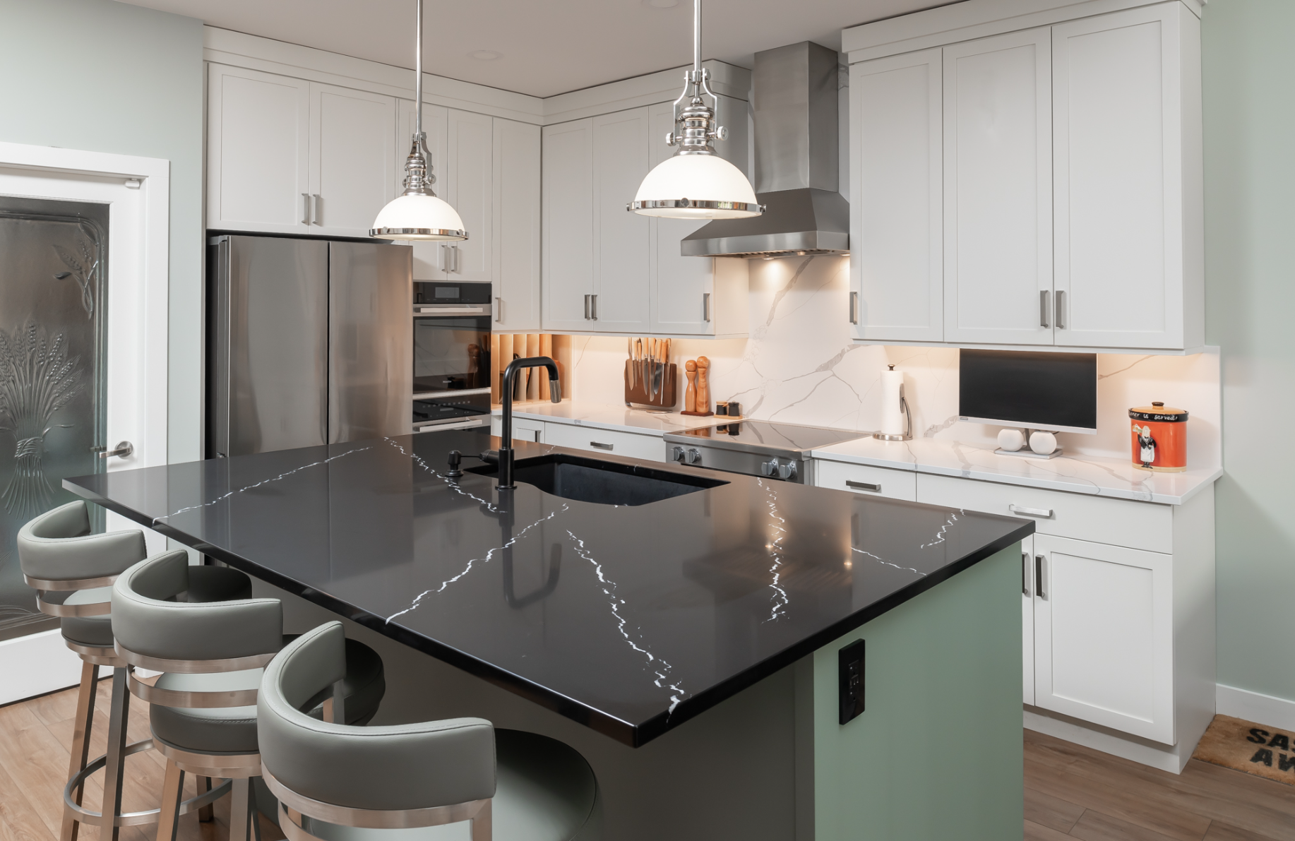 Modern kitchen renovation in Chilliwack by Master Painting and Renovations featuring white cabinetry, quartz island countertop, and pendant lighting