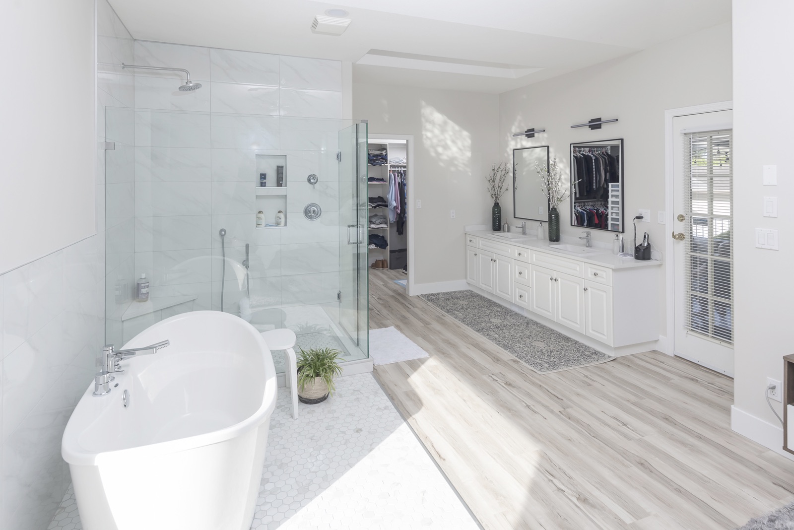 Renovated bathroom with a freestanding tub, frameless glass shower, and double vanity